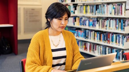 Student sitting at a desk in NCI library